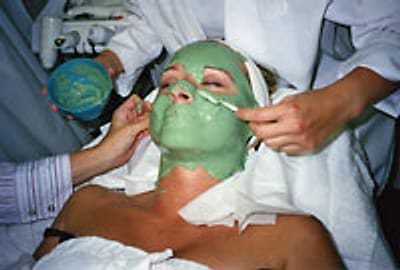 Students applying a green facial mask during a supervised facial