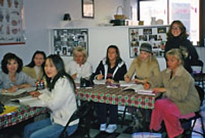 Nail technology students practicing at the school nail tables