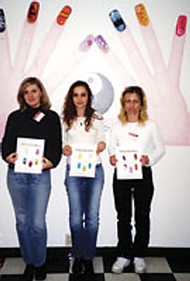 Three nail technology students holding their nail-art practice charts
